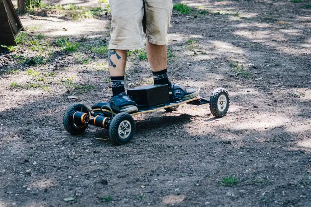 Pieds posés sur une board Evo-Spirit immobile sur un chemin forestier, sans effort physique requis