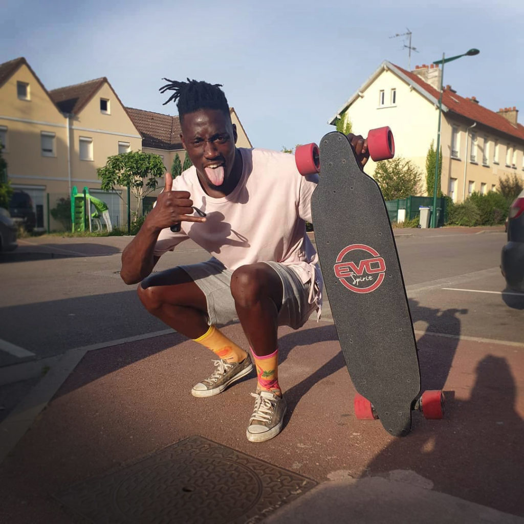Omar bienheureux, avec son skate électrique longboard Curve v3